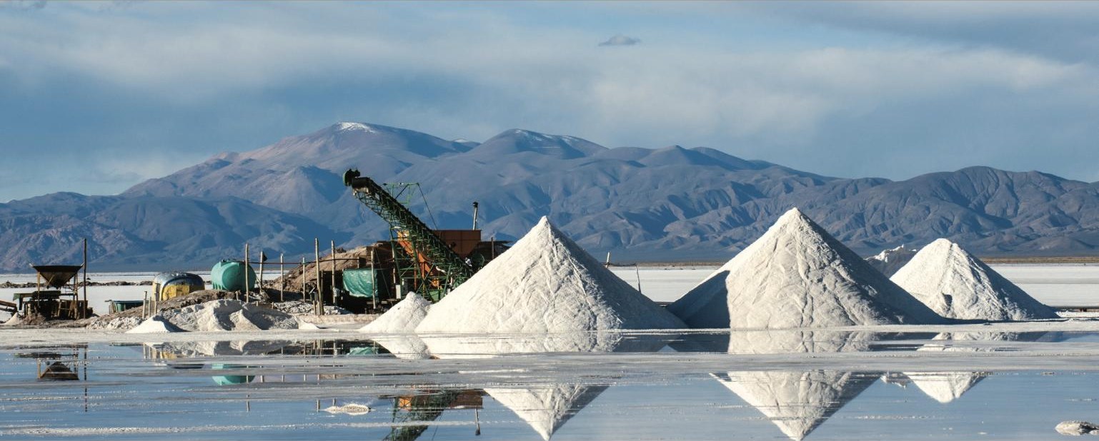 Salt harvest on a salt flat with mountains in the background